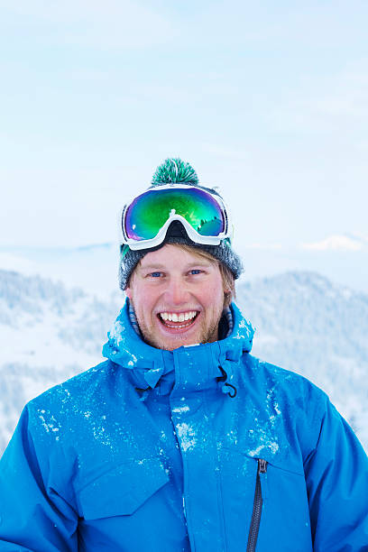 man smiling in snow - posing with ski stockfoto's en -beelden