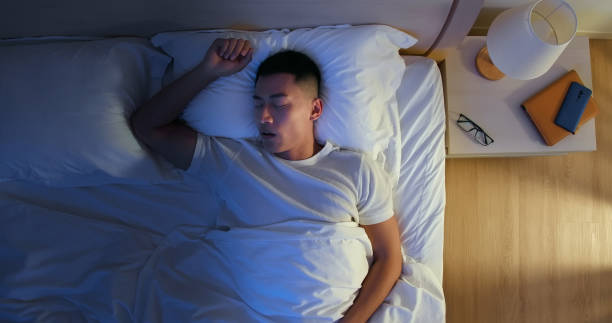 Man Snores At Night top view of asian young man snores when he sleep at night man sleeping in bed top view stock pictures, royalty-free photos & images