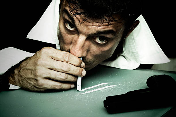Man Snorting Cocaine Off Table stock photo