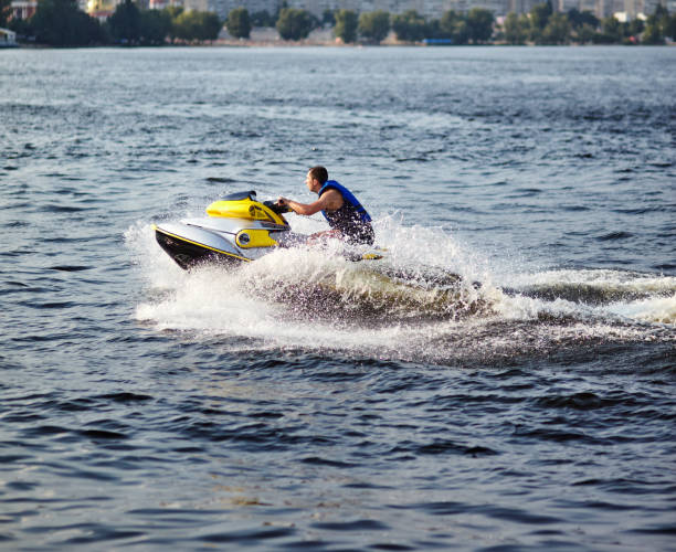 man speeding on jet ski on lake during summer vacation - vattenskoter motor bildbanksfoton och bilder