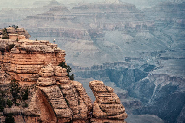 Man standing on edge on a cliff in the Grand Canyon, USA person standing on very edge of cliff in the grand canyon south rim stock pictures, royalty-free photos & images