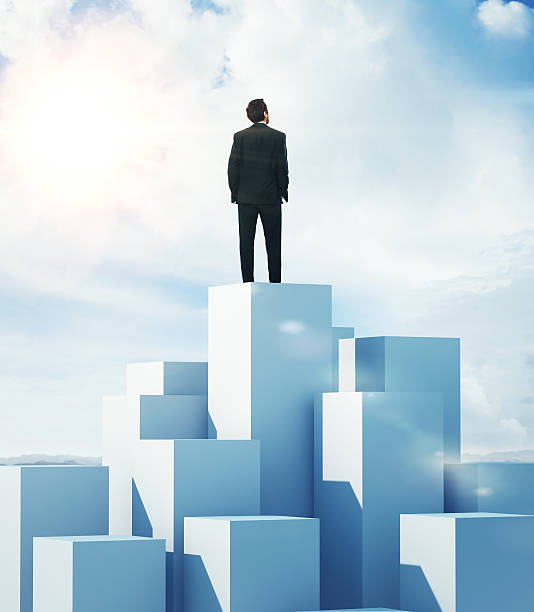 Man standing on highest cube stock photo