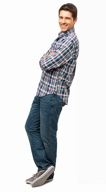 Man Standing With Arms Crossed - Isolated Full length portrait of a happy young man standing with arms crossed. Vertical shot. Isolated on white. leaning stock pictures, royalty-free photos & images