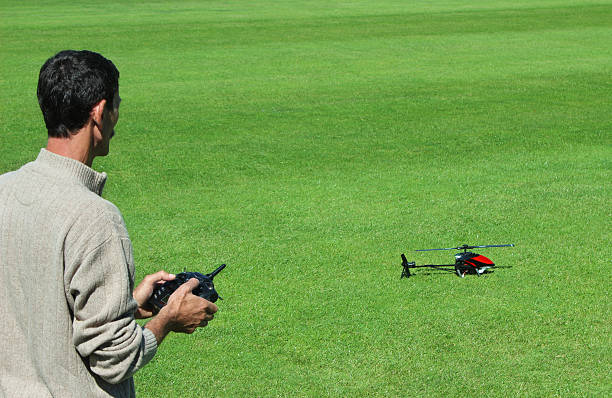 Man starting to fly a remote control helicopter stock photo