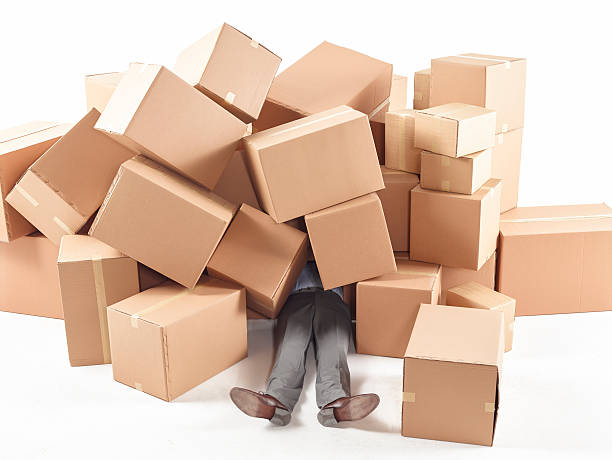 Man stuck under the with boxes stock photo
