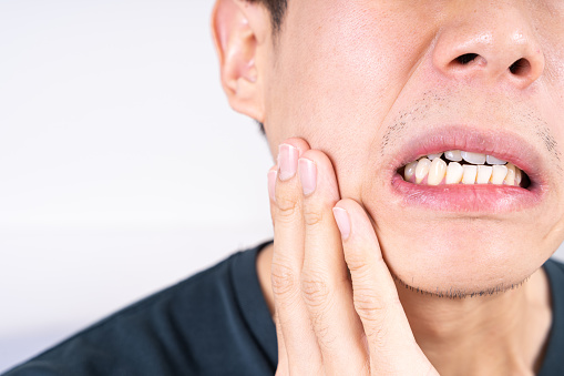 man-suffering-from-toothache-hand-touching-wisdom-tooth-dental-picture-id1278815419?b=1&k=20&m=1278815419&s=170667a&w=0&h=ddvhTyPtju0N4wnT04KuEPYldvXP4OSdr3ASrRiUtRY=