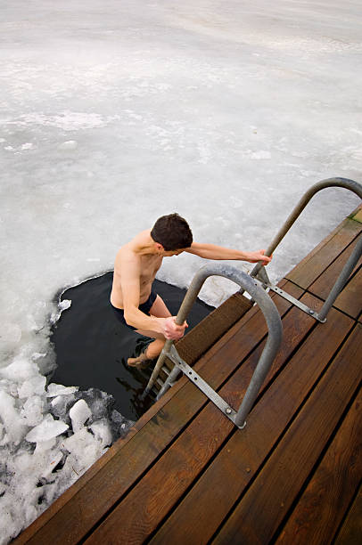 man taking a dip in the frozen sea - ice swimming stockfoto's en -beelden
