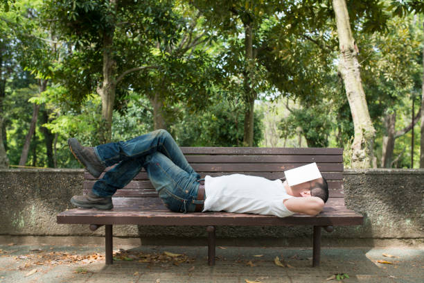 ベンチで寝ている男 - 気軽に ストックフォトと画像