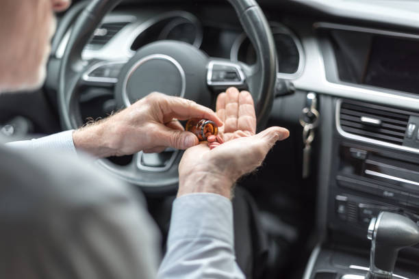 Man taking drugs before driving stock photo