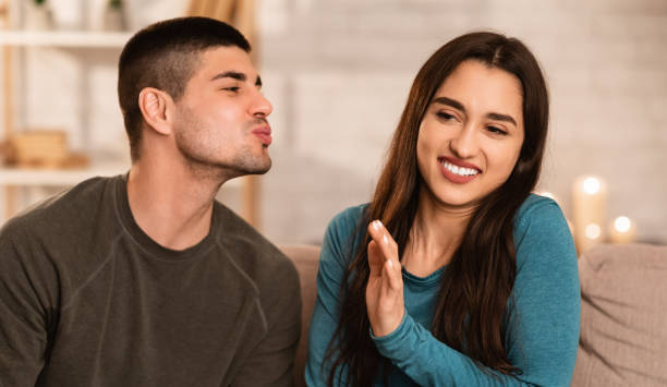 Man trying to kiss a woman, she rejecting him Bad Breath Concept. Girl ignoring and rejecting boy who trying to kiss her bad breath stock pictures, royalty-free photos & images