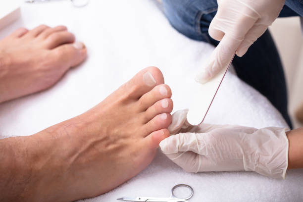 Man Undergoing Pedicure Process In Salon High Angle View Of Beautician Filling Man's Nail In Salon man pedicure stock pictures, royalty-free photos & images