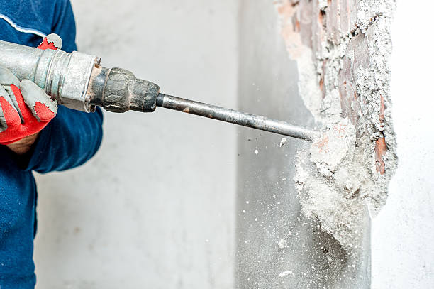 man using a jackhammer to drill into wall stock photo