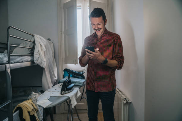 Man using a mobile phone at home stock photo