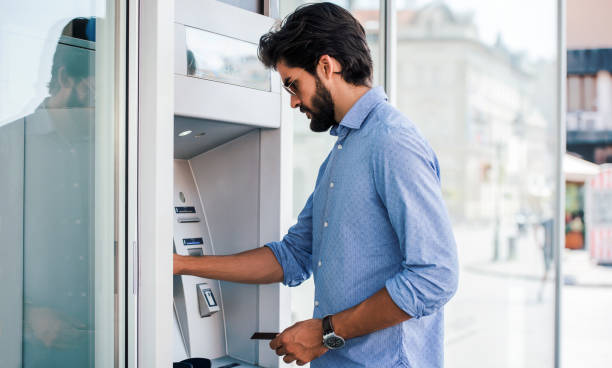 Man using an cash dispenser on the street stock photo