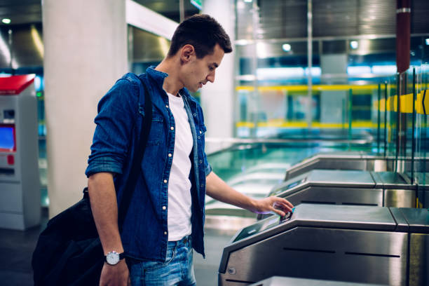 Man using card for getting through ticket barrier stock photo