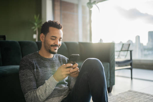 Man using smartphone at home stock photo