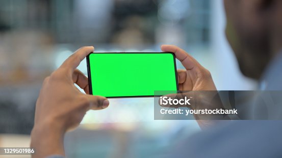 istock Man Using Smartphone with Green Chroma Key Screen, Rear View 1329501986