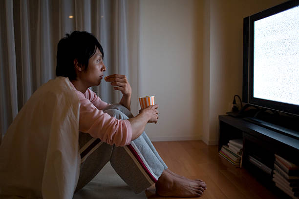 Man watches TV while eating popcorn watching tv stock pictures, royalty-free photos & images