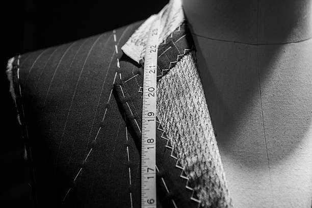 Man wearing a suit close-up with tape measure around neck A close up of tailor's baste jacket. tailor stock pictures, royalty-free photos & images
