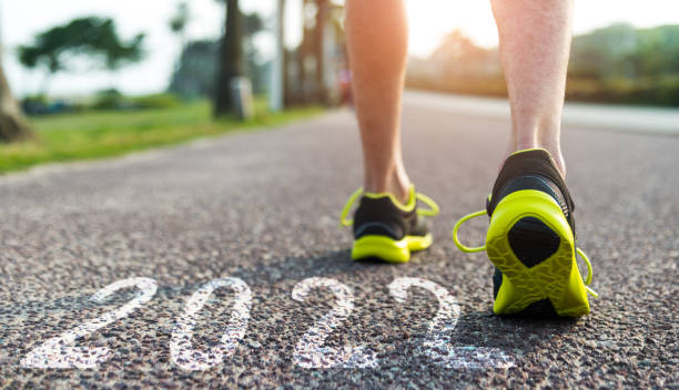 Man wearing sneakers ready with new year number 2022 on the road stock photo