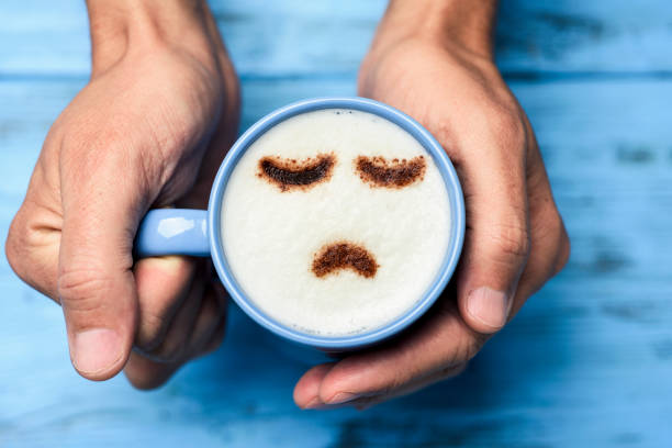 man with a cup of cappuccino with a sad face stock photo
