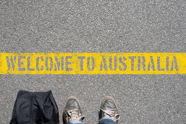 A man with a suitcase stands on the border with Australia stock photo