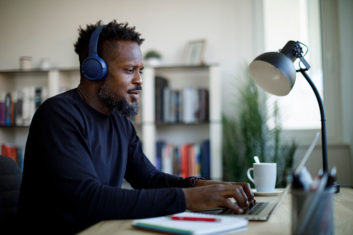 Man with bluetooth headphones working at home office