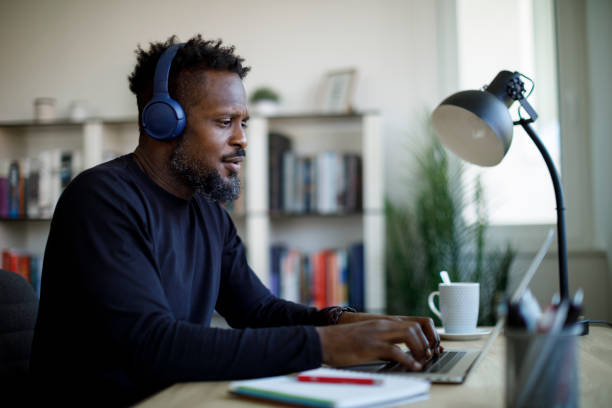 Man with bluetooth headphones working at home office stock photo