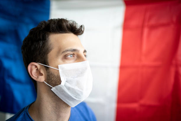homme avec le masque de visage et le drapeau français sur le fond - urgences france photos et images de collection