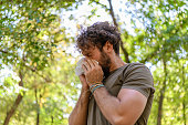 istock A Man with Flu is Walking in Public Park and Sneezing in Paper Tissues. 1331685786
