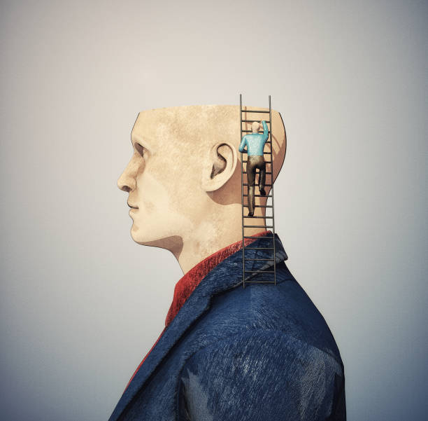 Man with half of head and one climbing a ladder into the head. stock photo