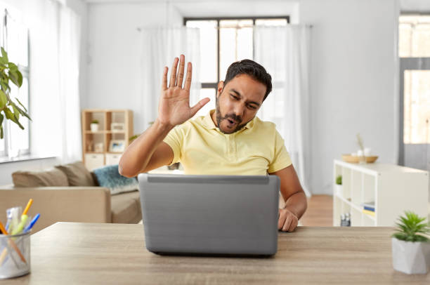man with laptop has video chat and makes high five technology, remote job and communication concept - happy indian man with laptop computer having video chat and making high five gesture at home office high five stock pictures, royalty-free photos & images