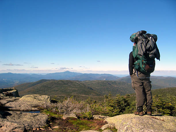 A man with large backpack standing atop a mountain Hiker on Mt. Marcy, in Adirondack State Park of New York. adirondack state park stock pictures, royalty-free photos & images