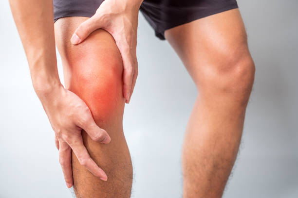 man with muscle pain on grey background. Elderly have knee ache due to Runners Knee or Patellofemoral Pain Syndrome, osteoarthritis, arthritis, rheumatism and Patellar Tendinitis. medical concept stock photo