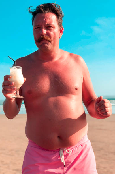 man-with-mustache-and-cocktail-on-the-beach-picture-id1141775855