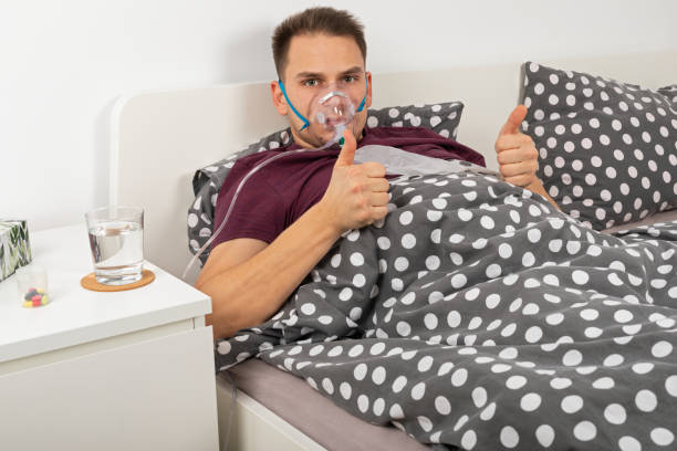 Man with oxygen mask at home stock photo