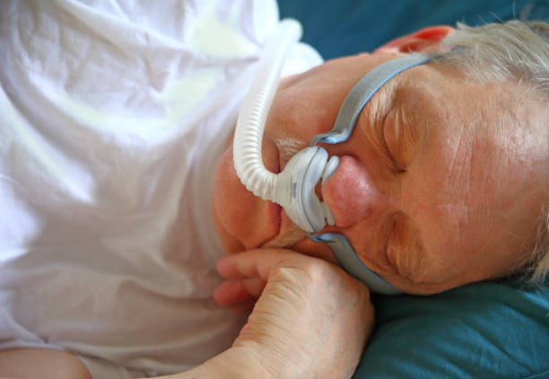 Man with sleep apnea uses breathing device stock photo