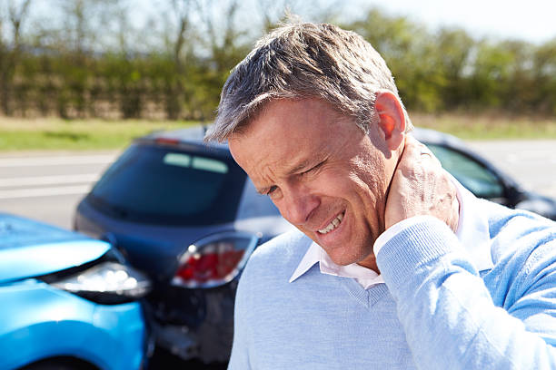 man with whiplash after traffic collision - fixing car pain stockfoto's en -beelden