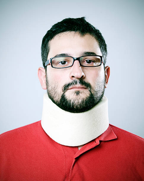 Man with whiplash wearing spectacles and neck brace stock photo