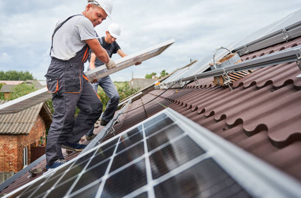 Man worker mounting solar panels on roof of house. stock photo