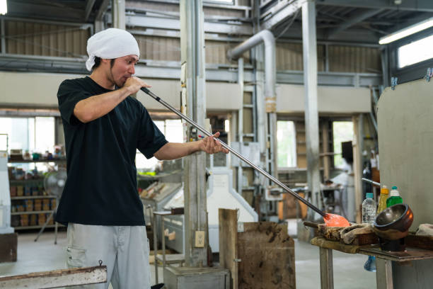 Man working at a glass factory stock photo