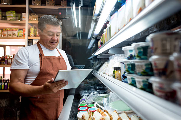 man working at a grocery store - stock market stok fotoğraflar ve resimler