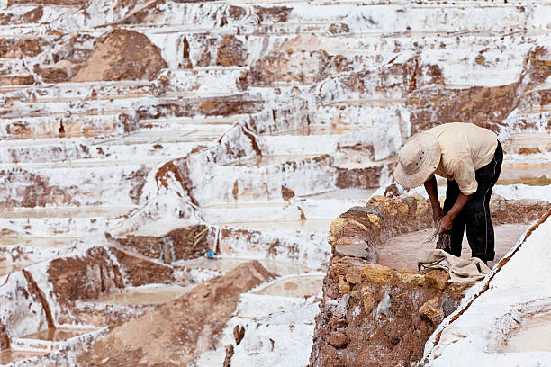 Man working at salt ponds in Maras, Cuzco, Sacred Valley stock photo