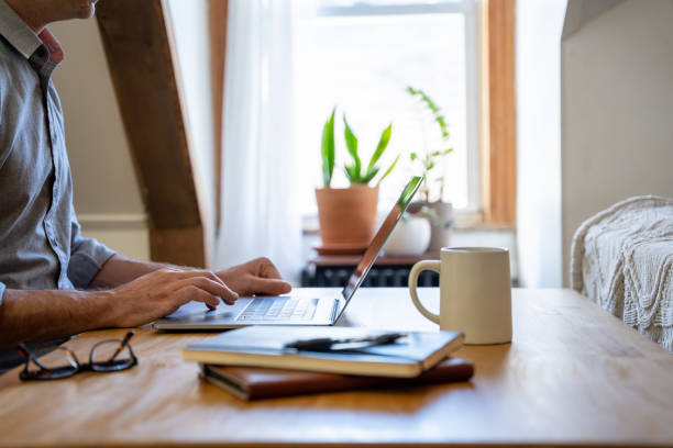 Man working from home at a table in is home office. stock photo