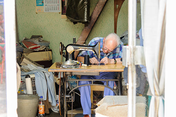 Man working on an old treadle sewing machine stock photo