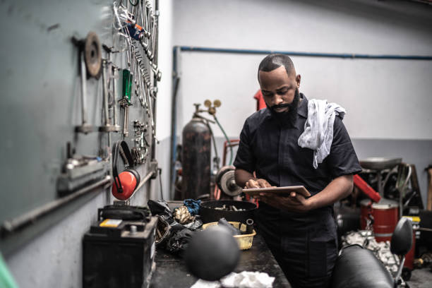 Man working with tablet in auto repair Car mechanics, workers, customers, satisfaction / Auto car repair service center. mechanic stock pictures, royalty-free photos & images