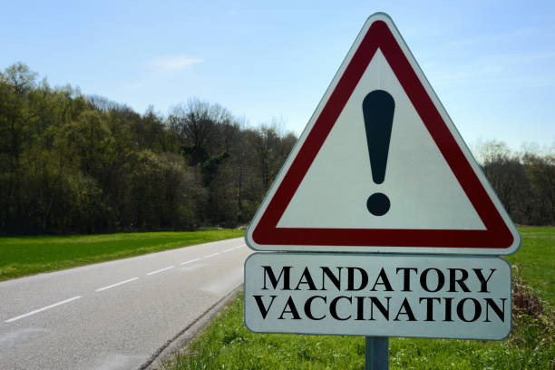 Mandatory vaccination Road traffic sign indicating mandatory vaccination | Panneau de circulation routière indiquant vaccination obligatoire vaccine mandate stock pictures, royalty-free photos & images
