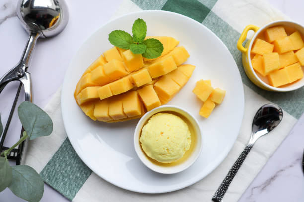 Mango Ice cream with ripe mango on the side in white plate at top view Tasty thai style mango ice cream mango ice cream stock pictures, royalty-free photos & images