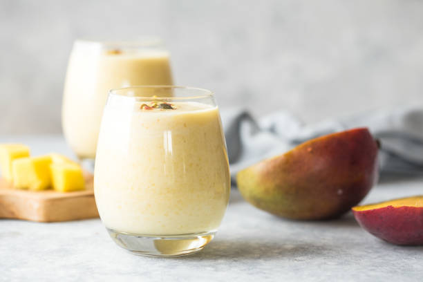 mango lassi, joghurt oder smoothie. gesunde probiotische kalte sommer - mango stock-fotos und bilder