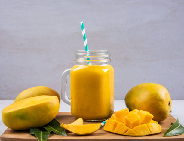 Mango Smoothie In A Bottle With Slices Of Mango Fruit Mango Smoothie In A Bottle With Slices Of Mango Fruit mango smoothie stock pictures, royalty-free photos & images